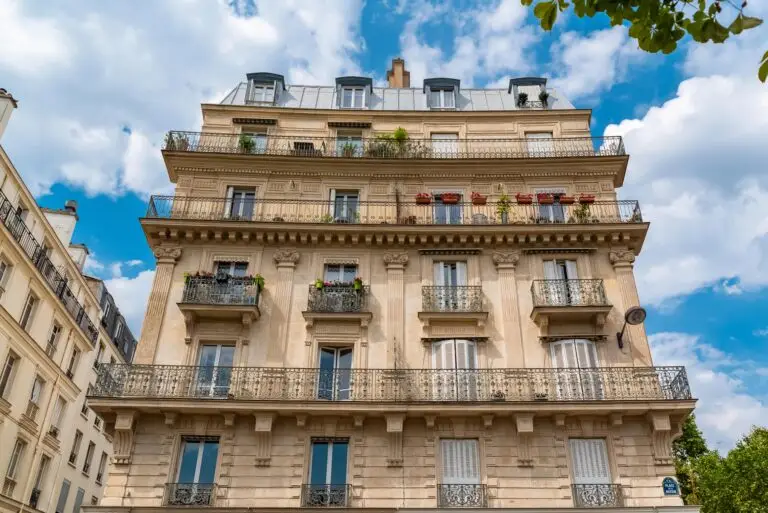 Façade d’immeuble haussmannien à Paris avec balcons en fer forgé et pierre de taille