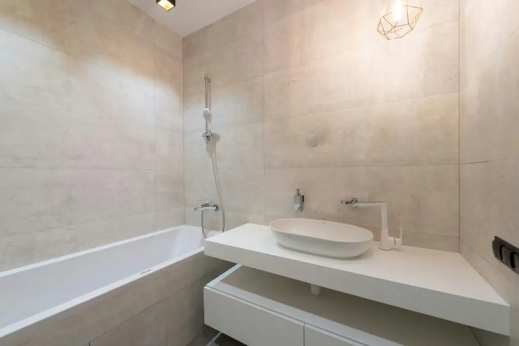 Elegant minimalist bathroom featuring a sleek bathtub and contemporary sink setup.