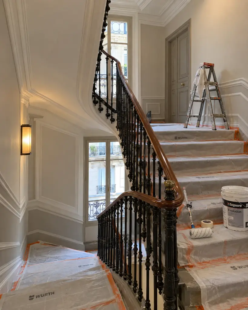 Cage d'escalier d'une copropriété parisienne en cours de mise en peinture, marches protégées