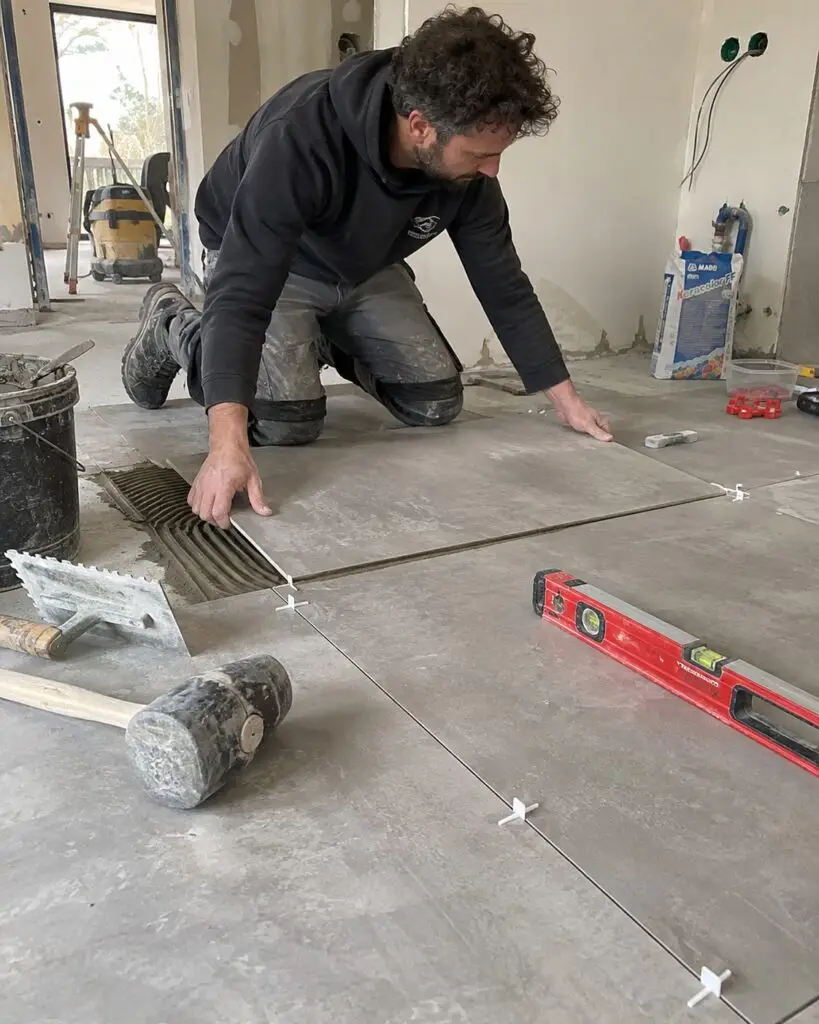 Carreleur NEO RENOV posant du carrelage grand format dans un appartement à Paris